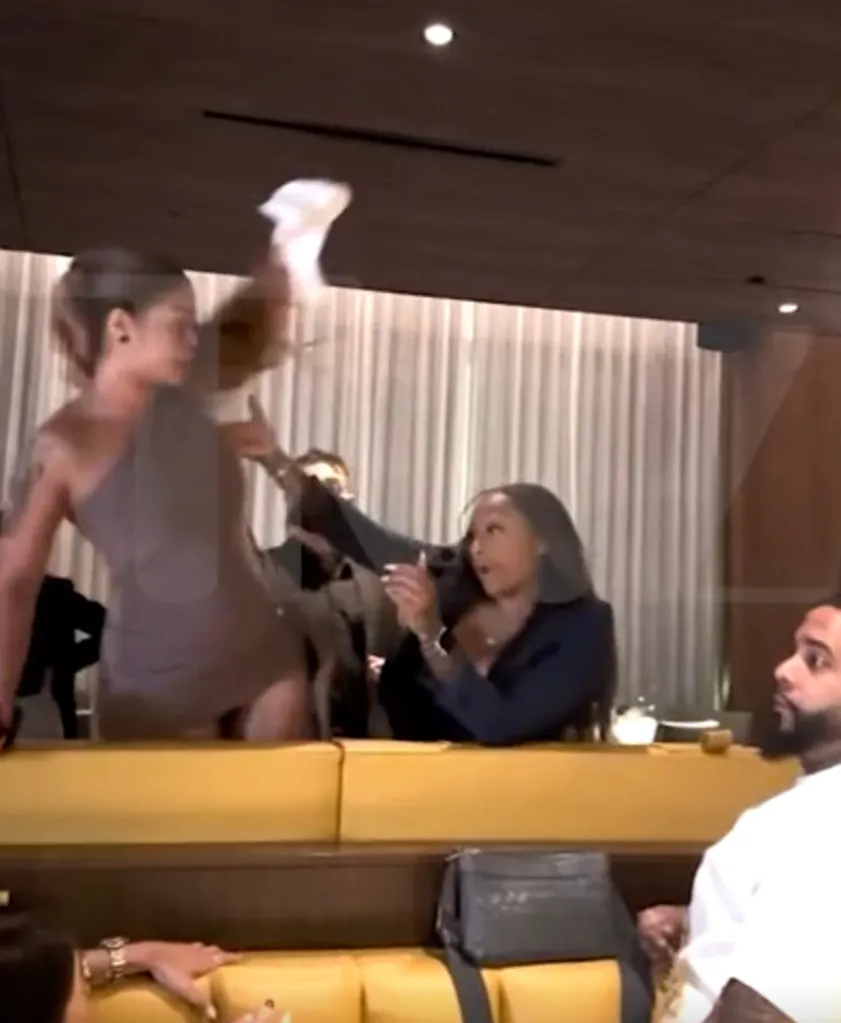 Two women fighting at a crowded restaurant.