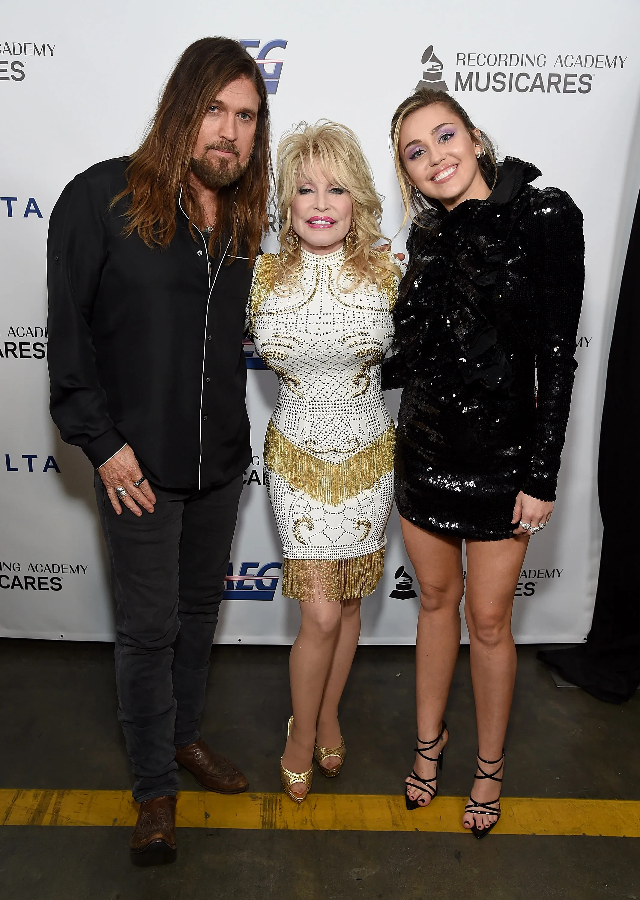 Billy Ray Cyrus, Dolly Parton, and Miley Cyrus pose together at MusiCares Person of the Year event.