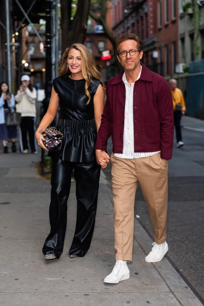 Blake Lively and Ryan Reynolds holding hands and walking on a city street.