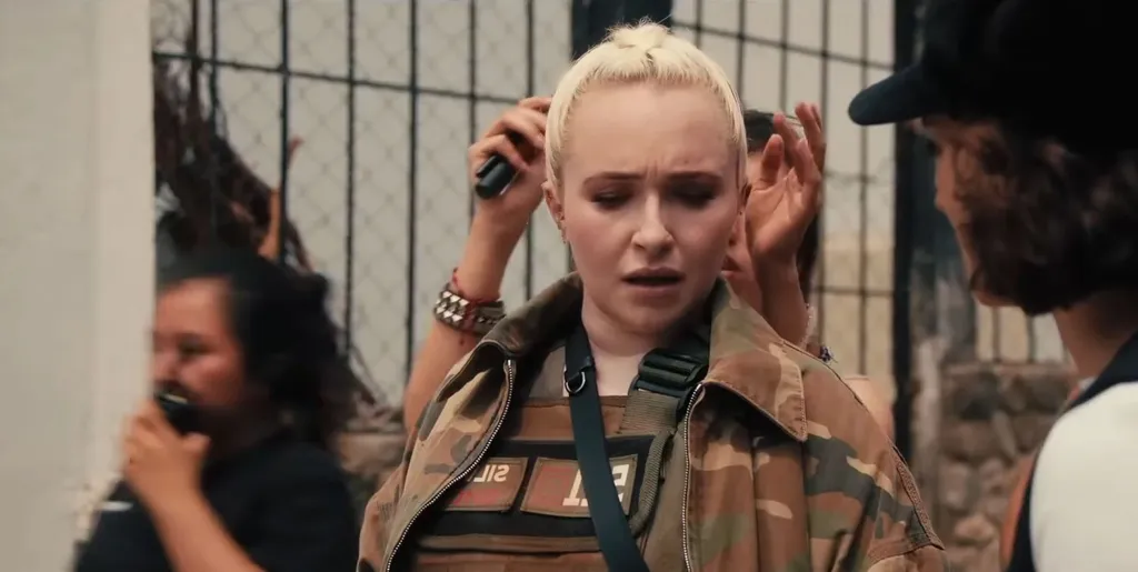 Hayden Panettiere in military-style clothing, with others around her.