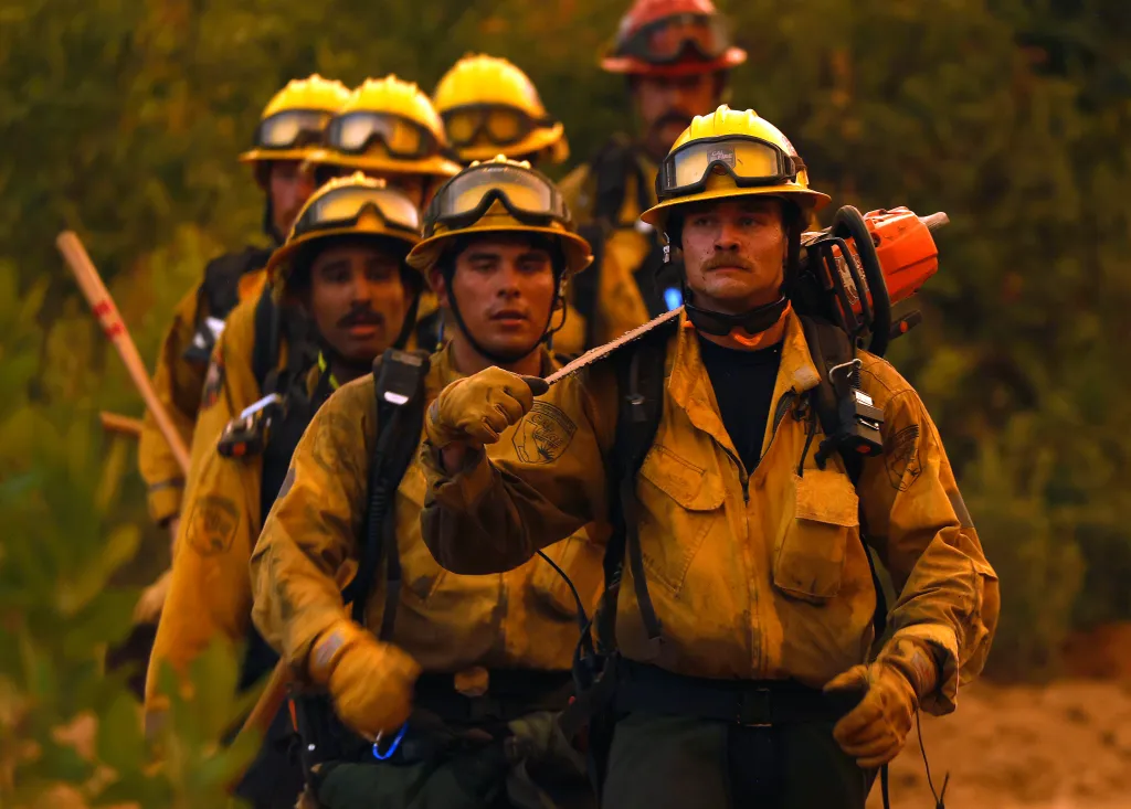 Cal Fire firefighters walk down a dozer line while battling the Pickett Fire.