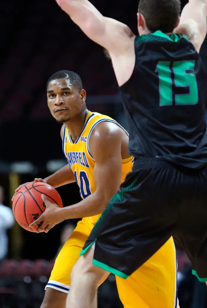 Cal State Bakersfield's Kevin Mays holds the basketball while being guarded by Utah Valley's Mitch Bruneel.