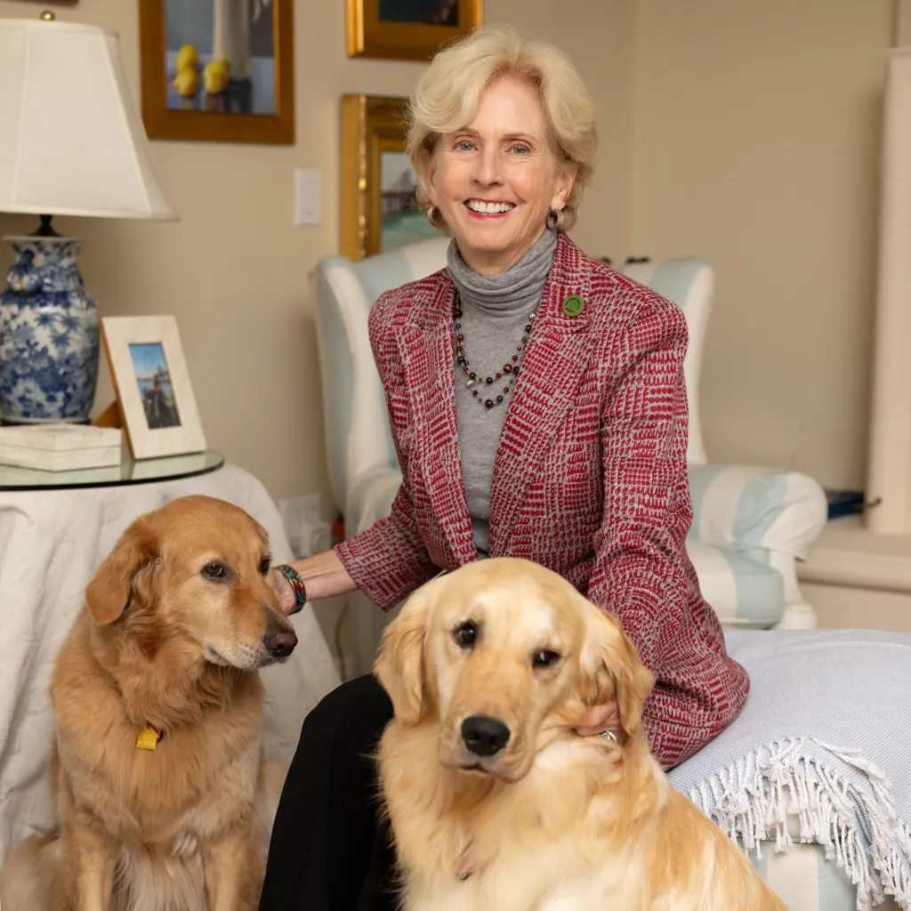 California Assemblywoman Diane Dixon seated with two golden retrievers.