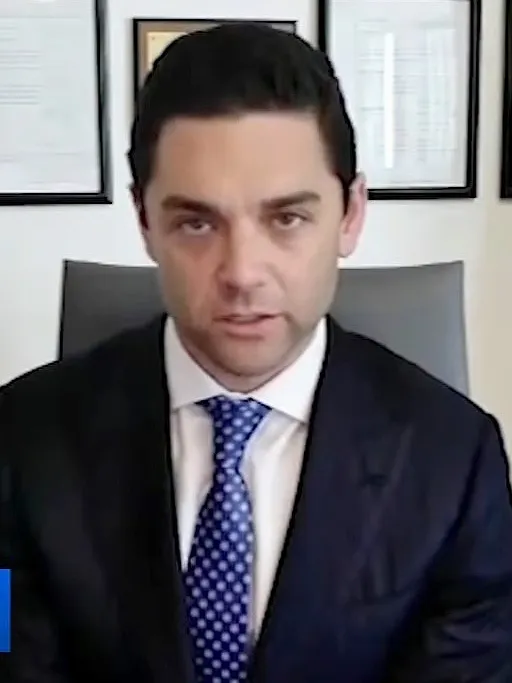 A man in a suit and tie speaking.