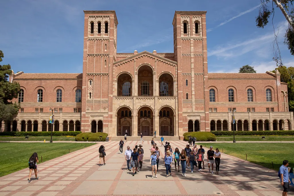 Powell Library at UCLA with students walking on the brick path in front of it.