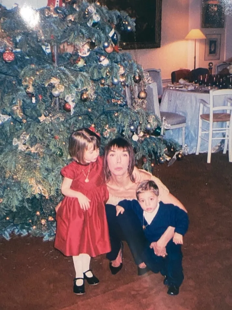 Mathilde Favier with her children, Carlo Agostinelli and his sister, in front of a Christmas tree.
