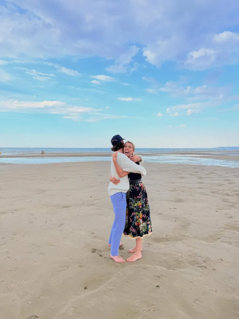 Carlo Agostinelli hugging his mother, Mathilde Favier, on a sandy beach.