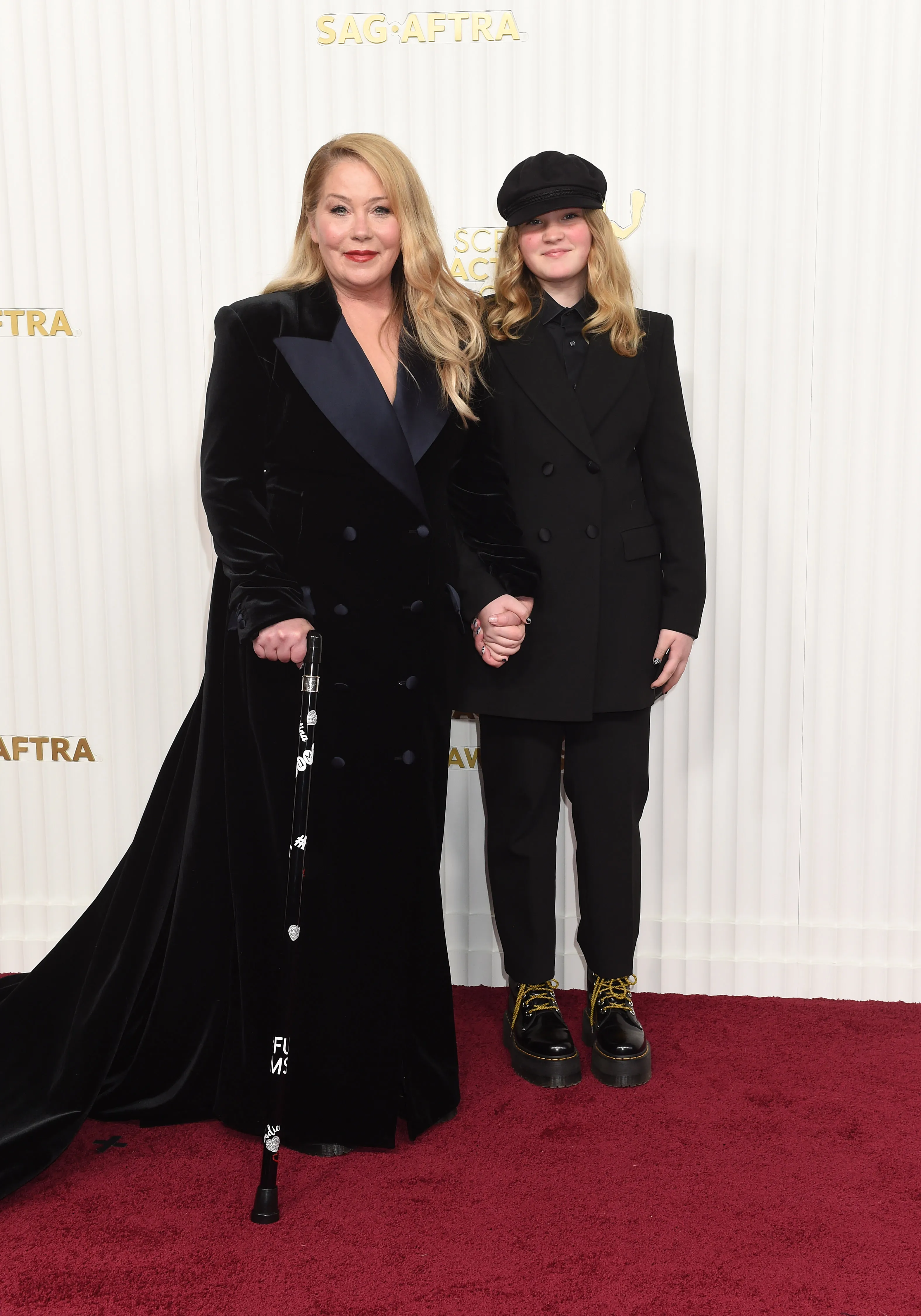 Christina Applegate and Sadie Grace LeNoble posing on the red carpet, both wearing black outfits.