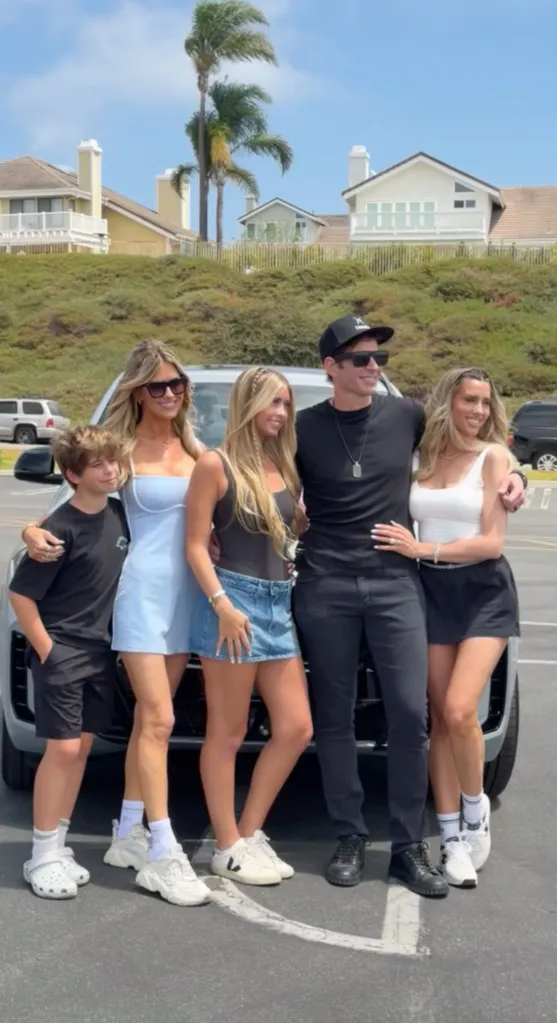 Christina Haack and Tarek El Moussa with their daughter and son, and Tarek's new wife, in front of a new car.