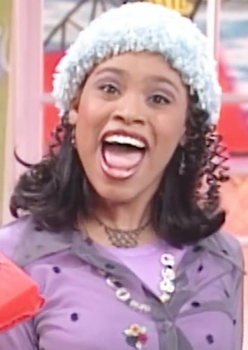 Christy Knowings with her mouth open, wearing a light blue fuzzy hat and a lavender shirt.