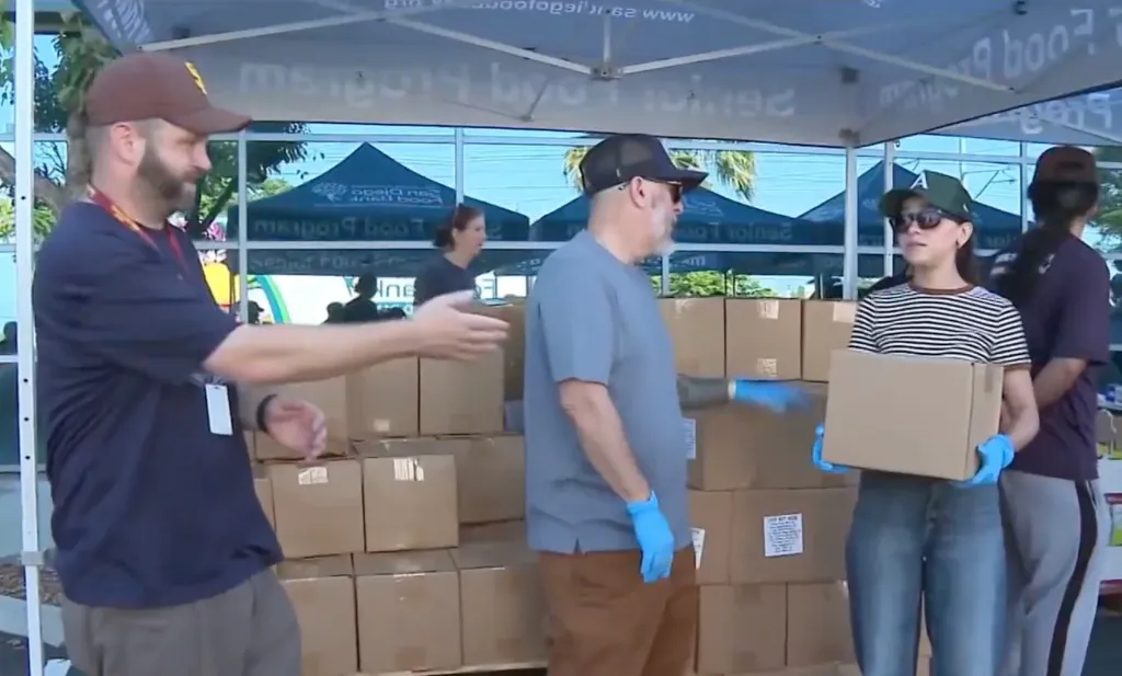 People handing out boxes at a back-to-school event.