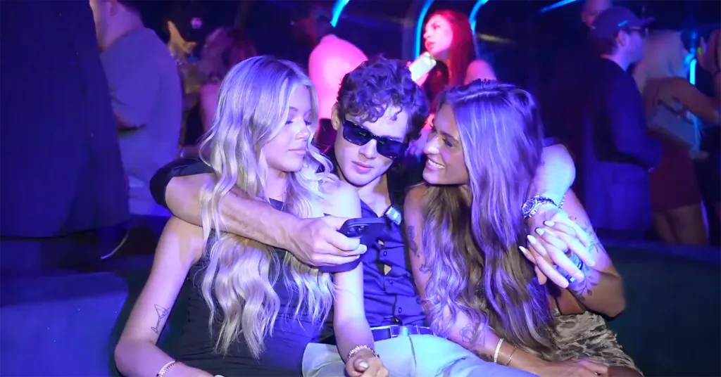 Clavicular embracing two women at a Miami club.