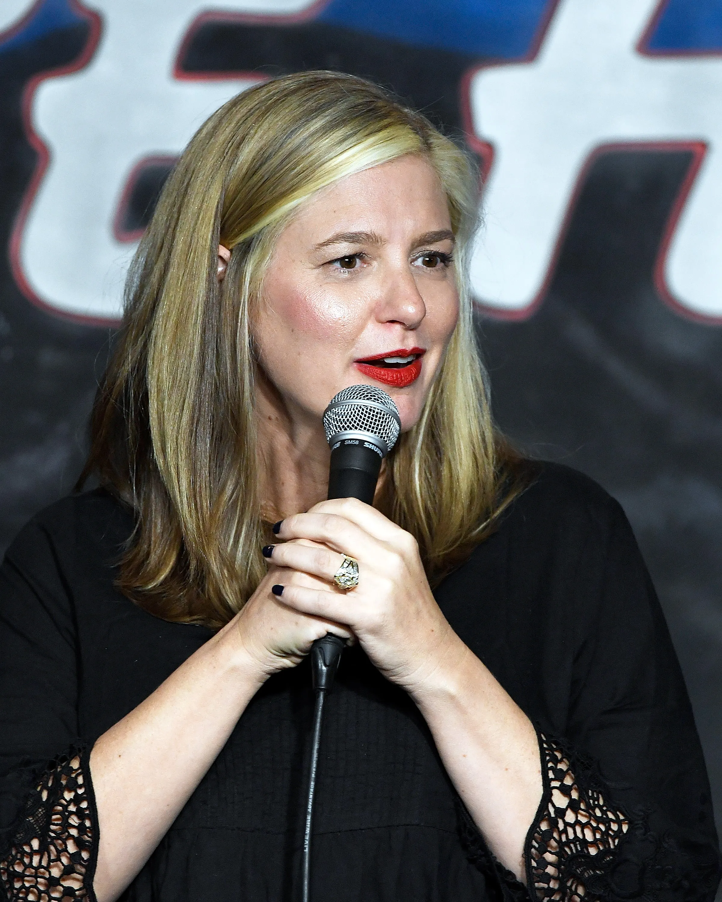 Comedian Christina Pazsitzky performs on stage.