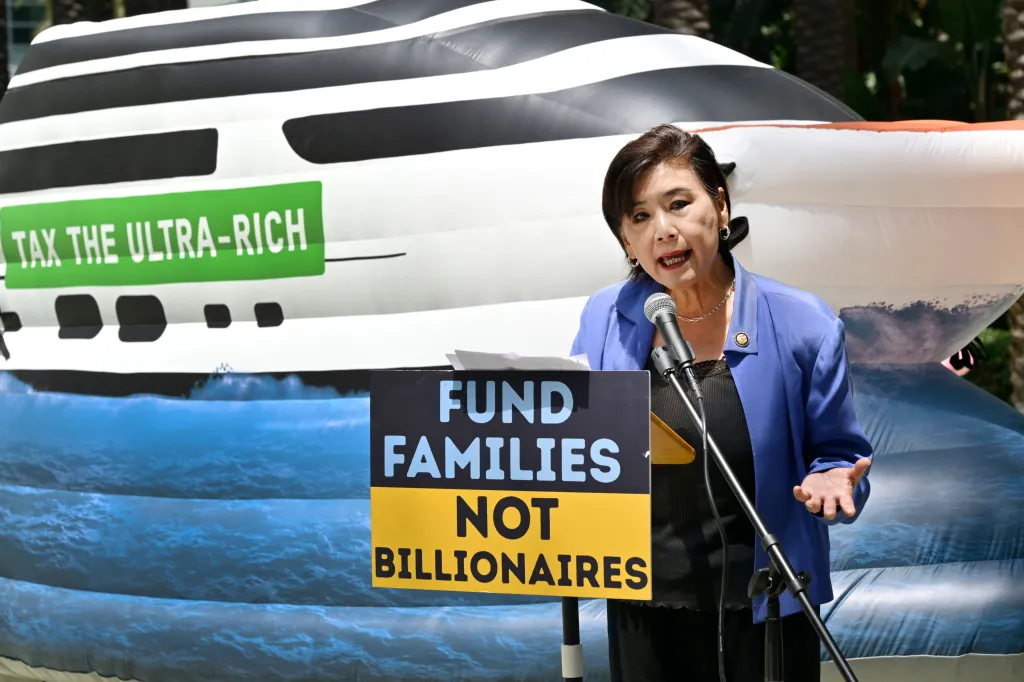 Congress member Judy Chu speaking at a podium with a sign that reads 
