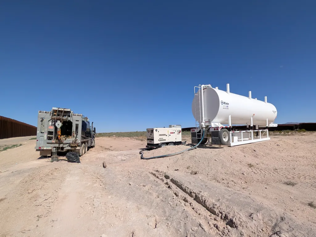 Construction equipment drilling wells for border wall construction.