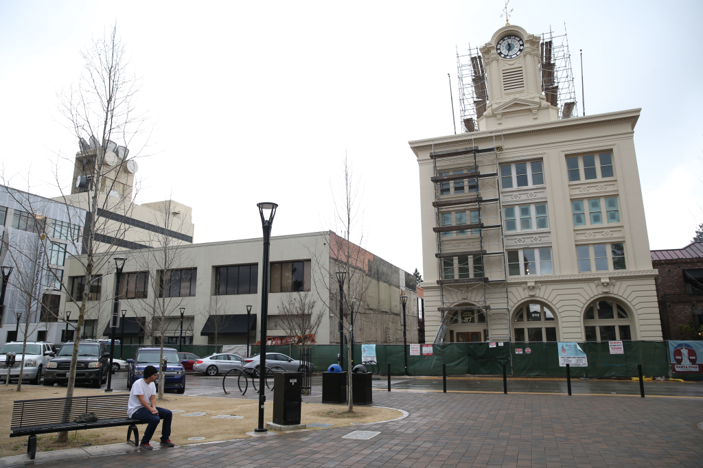 Courthouse Square and B Street in downtown Santa Rosa with a man sitting on a bench in the foreground.