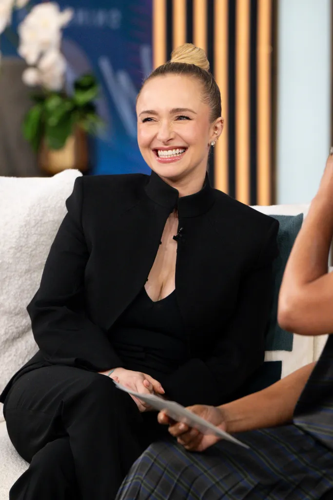 Hayden Panettiere in a black pantsuit, laughing on the Tamron Hall show.