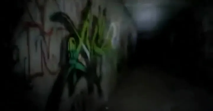 A dark, graffiti-covered tunnel.
