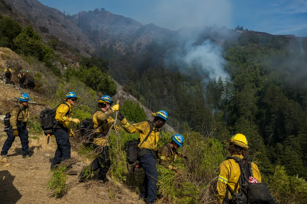 Firefighters clearing brush above Castro Canyon as the Timber Fire burns in Big Sur, California.