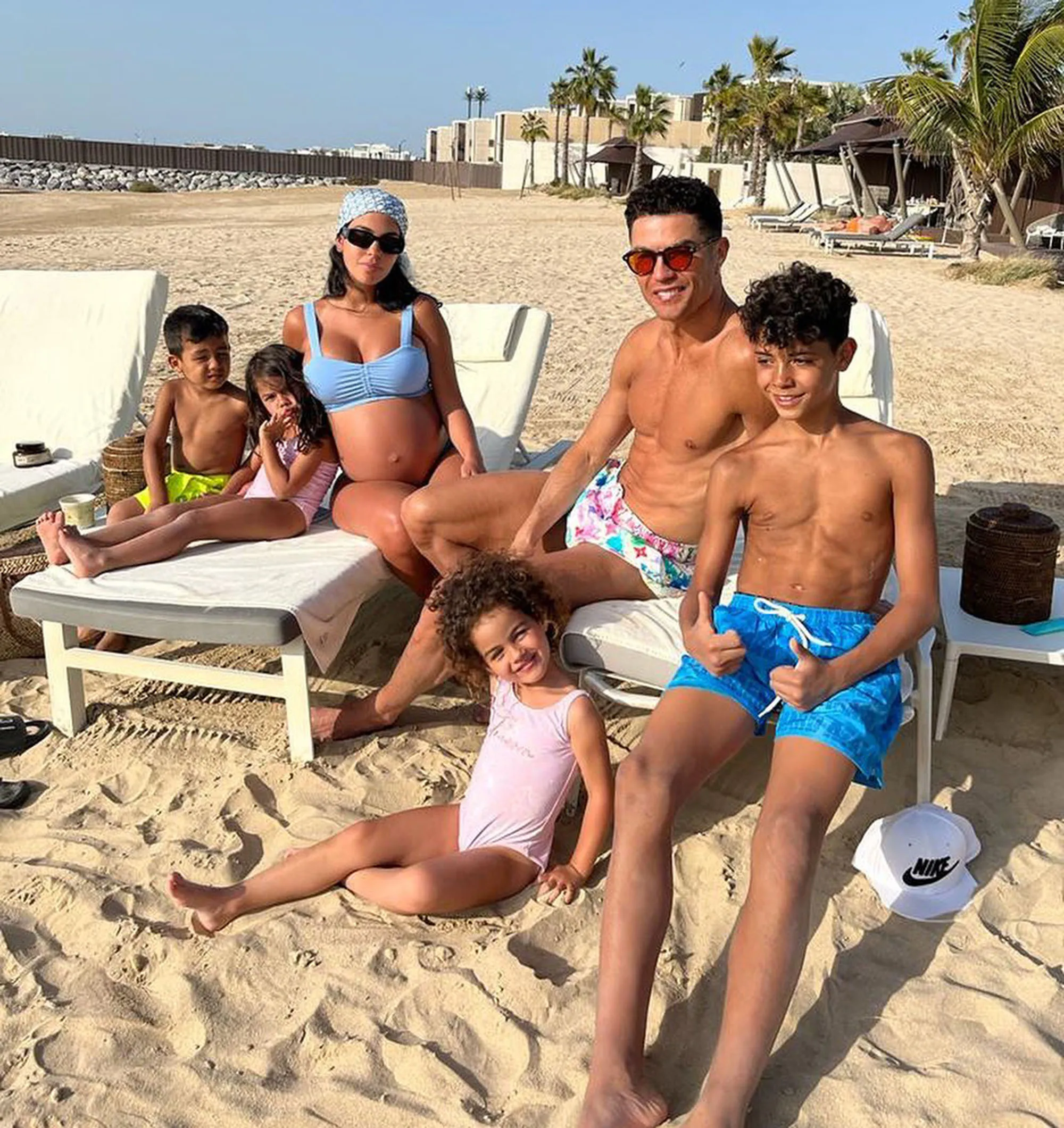 Cristiano Ronaldo and Georgina Rodriguez with their four children relaxing on a beach.