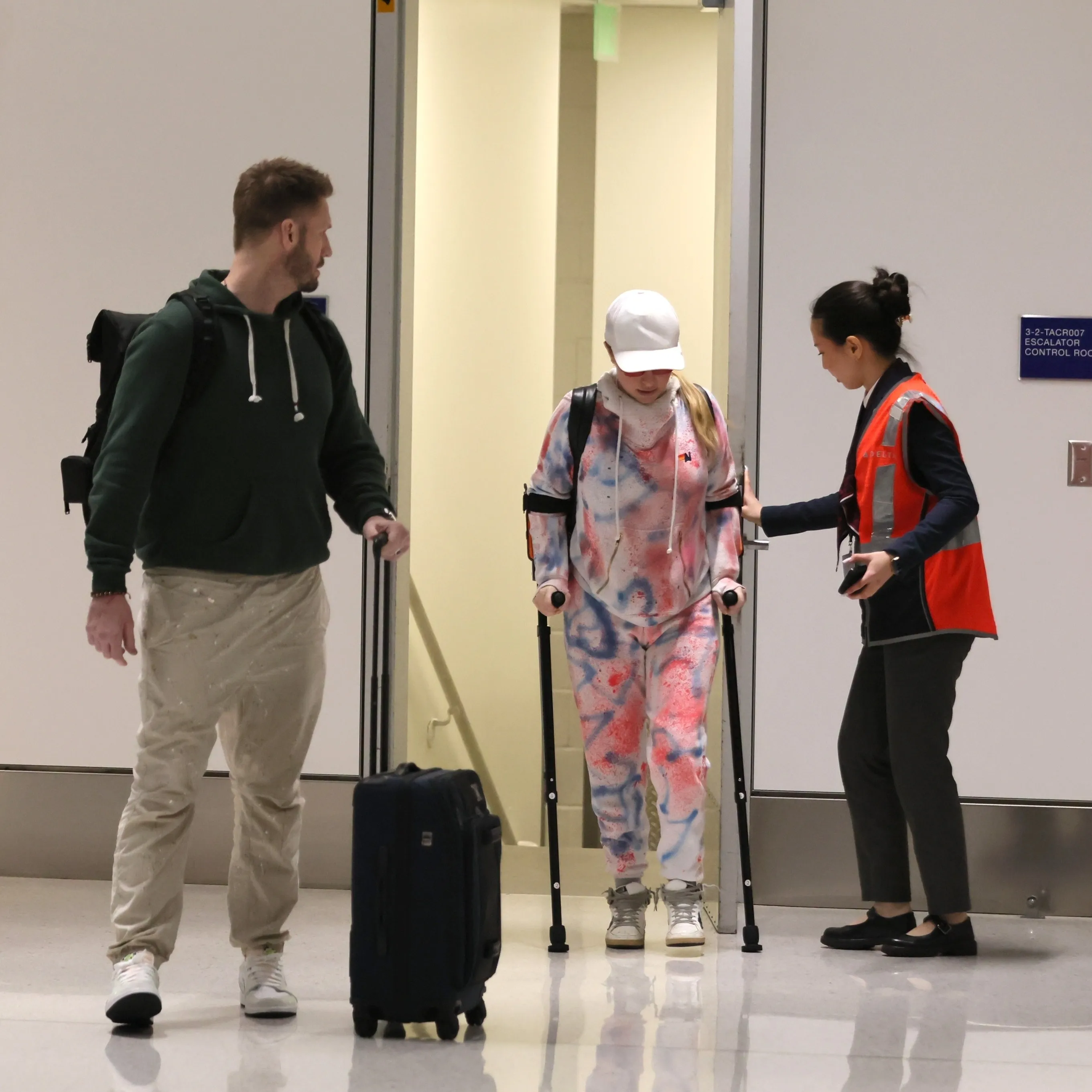 Hayden Panettiere on crutches with Brian Hickerson and an airport employee at LAX.