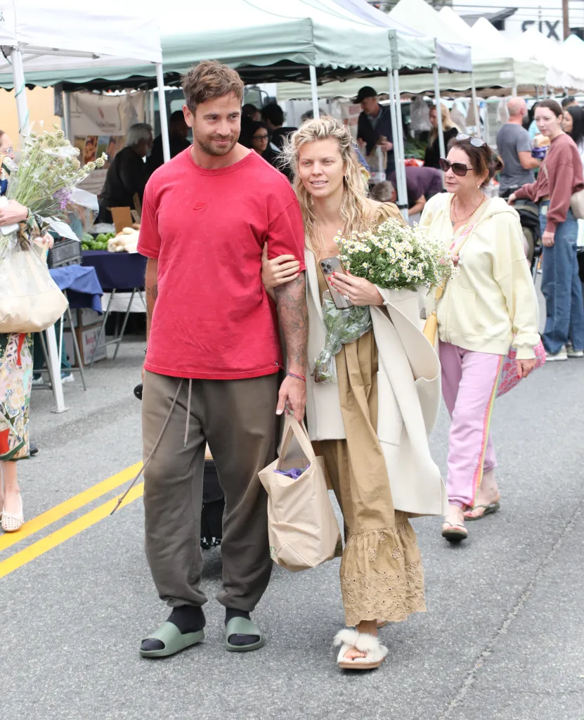 Danny Cipriani and AnnaLynne McCord walk at a market.