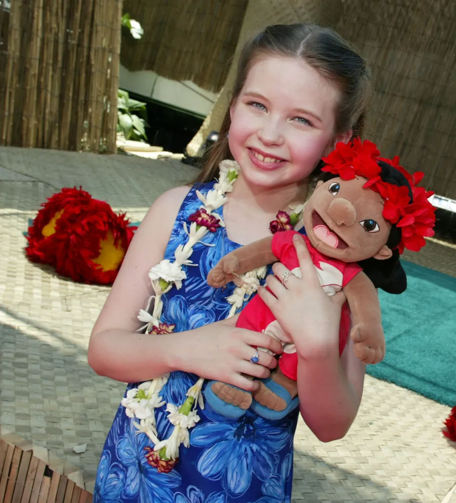 Daveigh Chase, voice of Lilo, holding a Lilo plush doll at the 