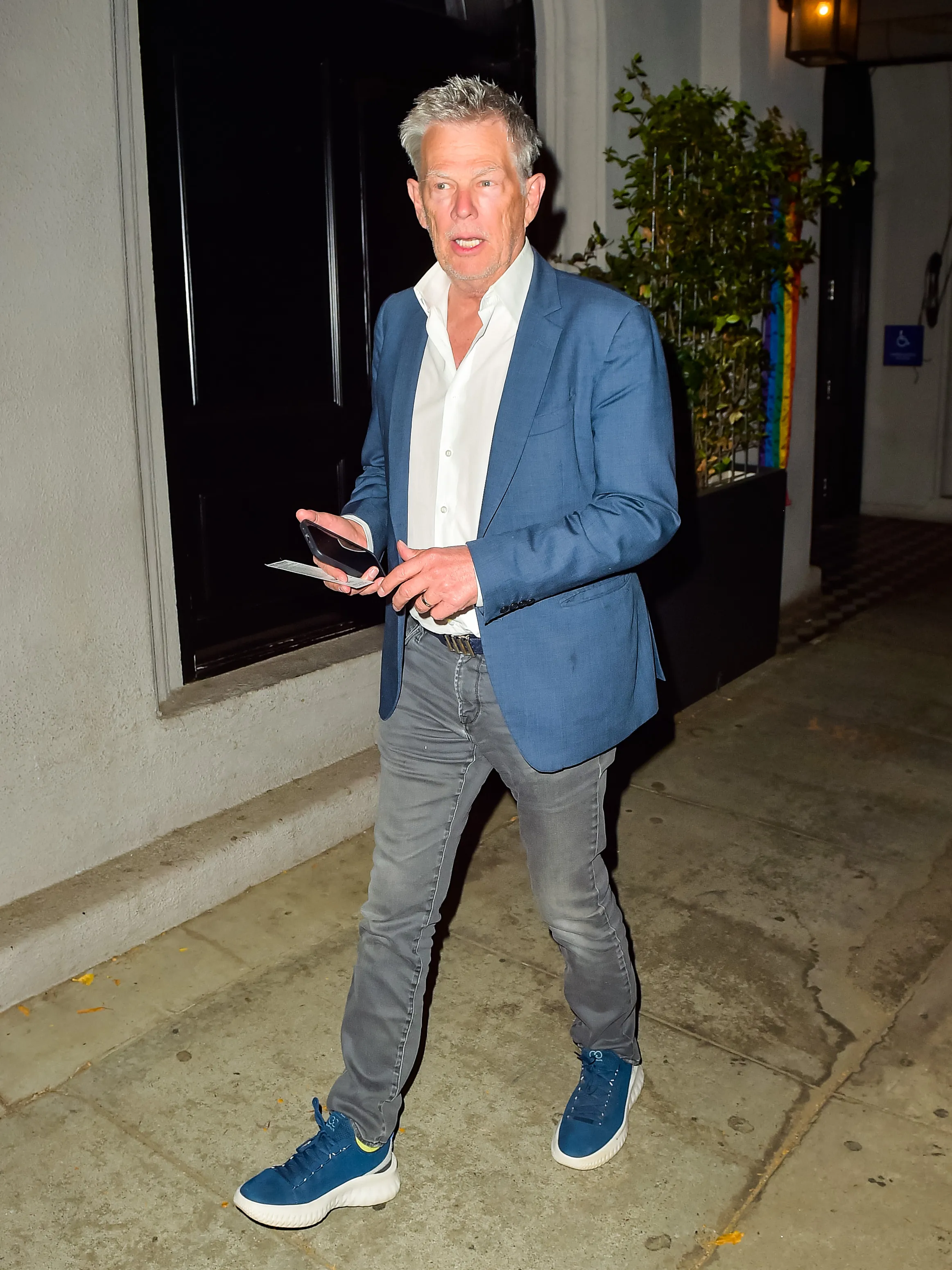 David Foster in a blue jacket, white shirt, and gray jeans.