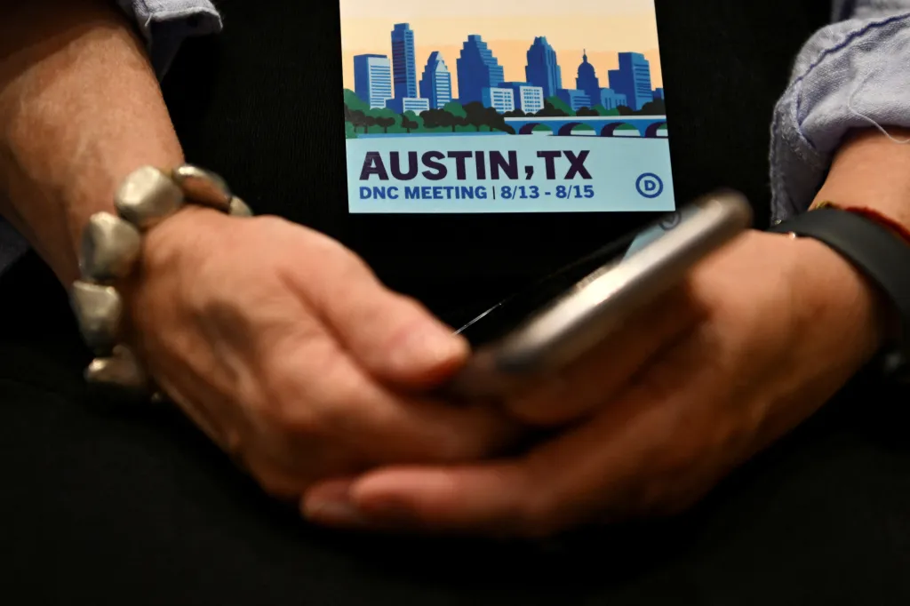 An attendee holds a mobile phone at the DNC Summer Meeting in Austin, Texas.