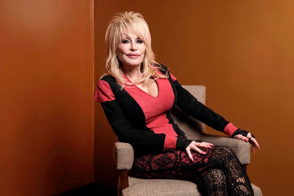 Dolly Parton posing while seated in a chair.