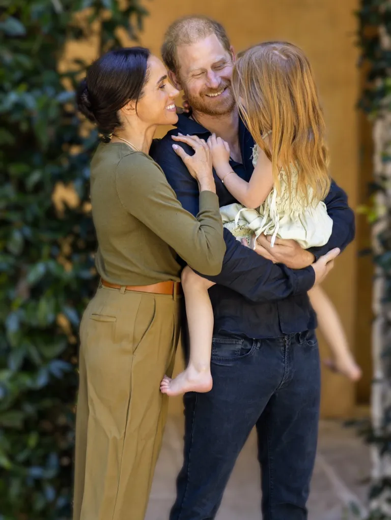 Meghan Markle, Prince Harry, and their daughter Lilibet share a warm embrace.