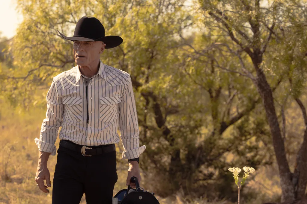 Ed Harris , in a grey striped shirt, black jeans and black cowboy hat, as Everett McKinney in Dutton Ranch.