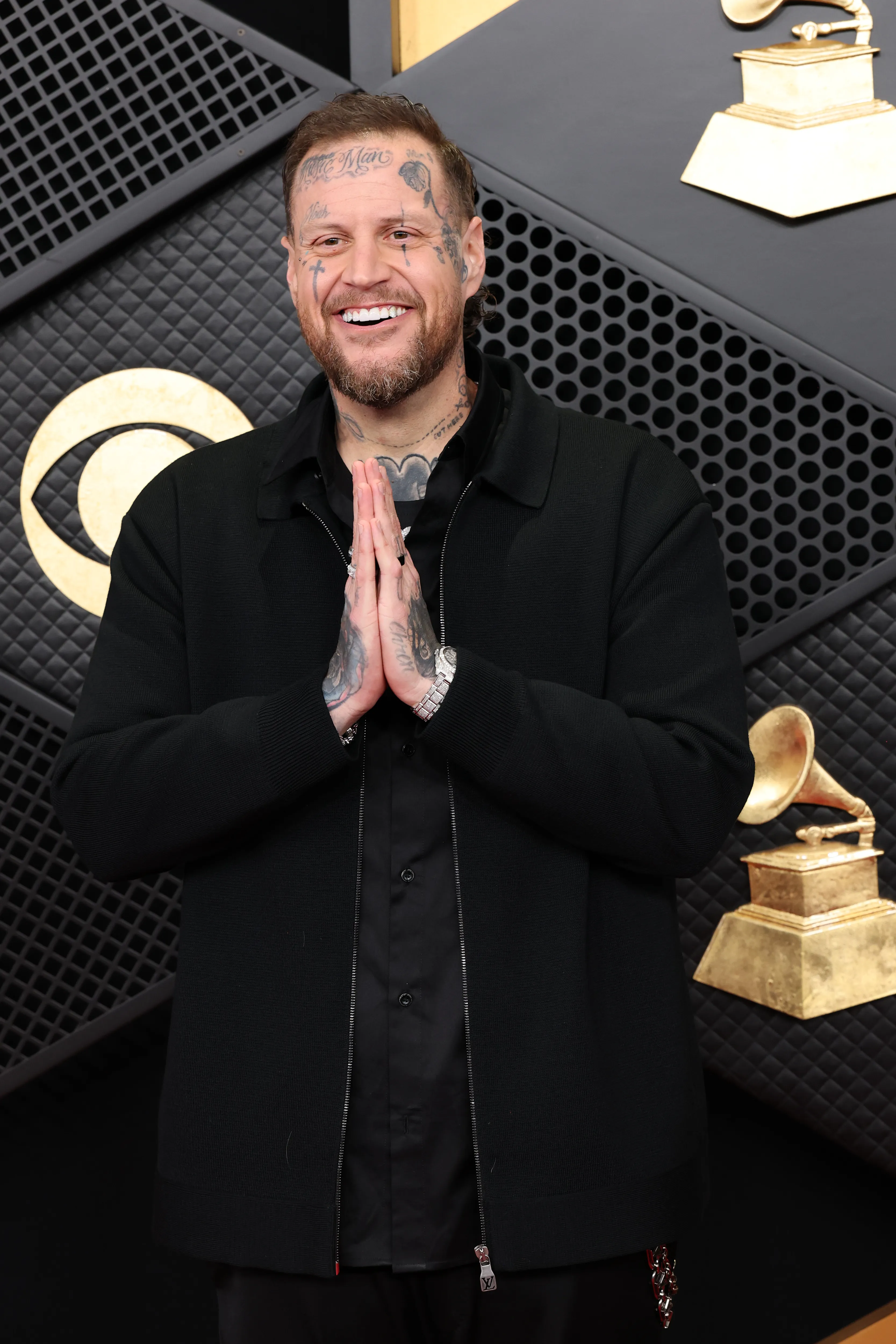 Jelly Roll smiling with hands pressed together at the 68th GRAMMY Awards.