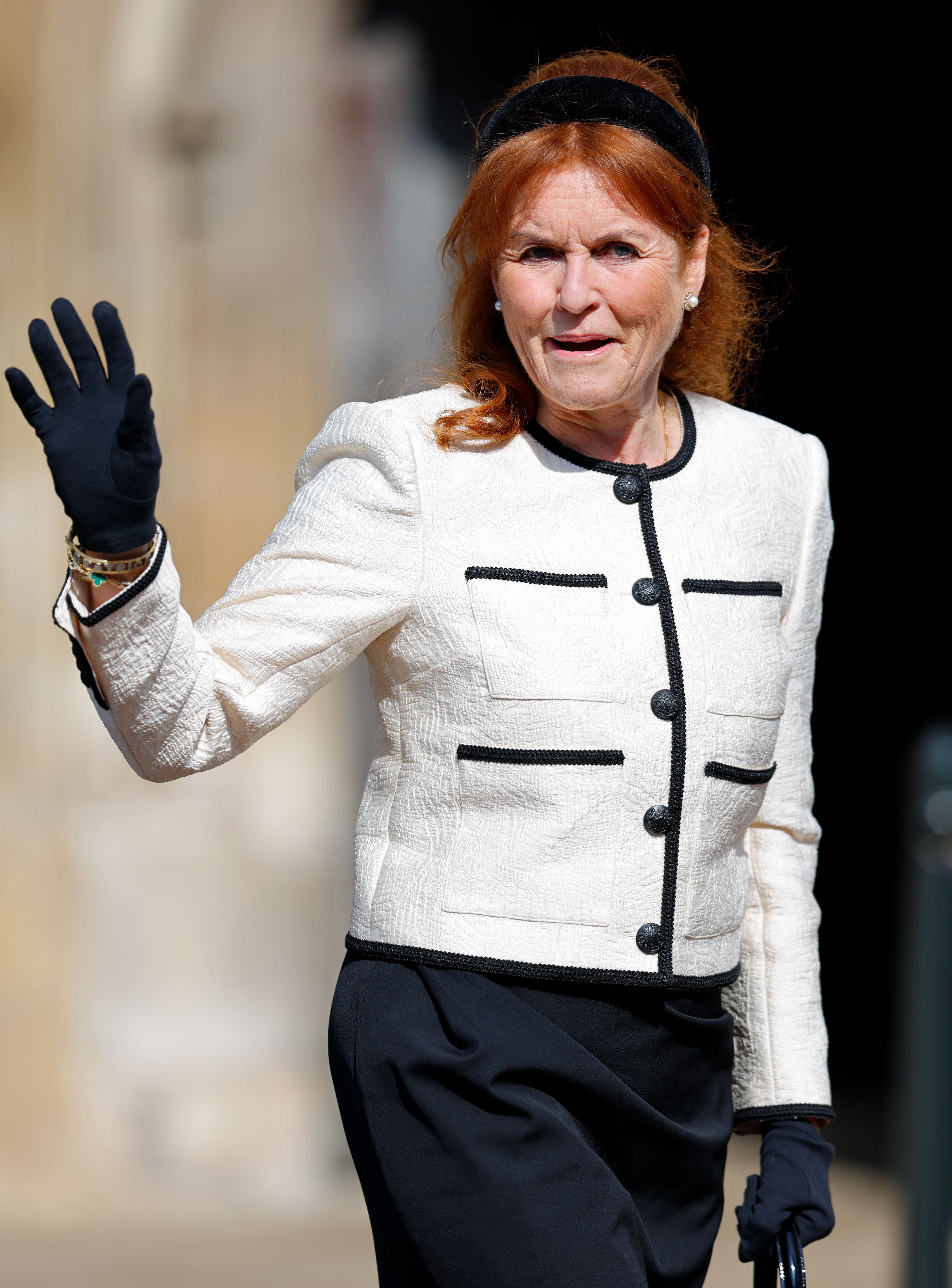 Sarah Ferguson, Duchess of York, wearing a white jacket with black trim, waves at the Easter Sunday service.