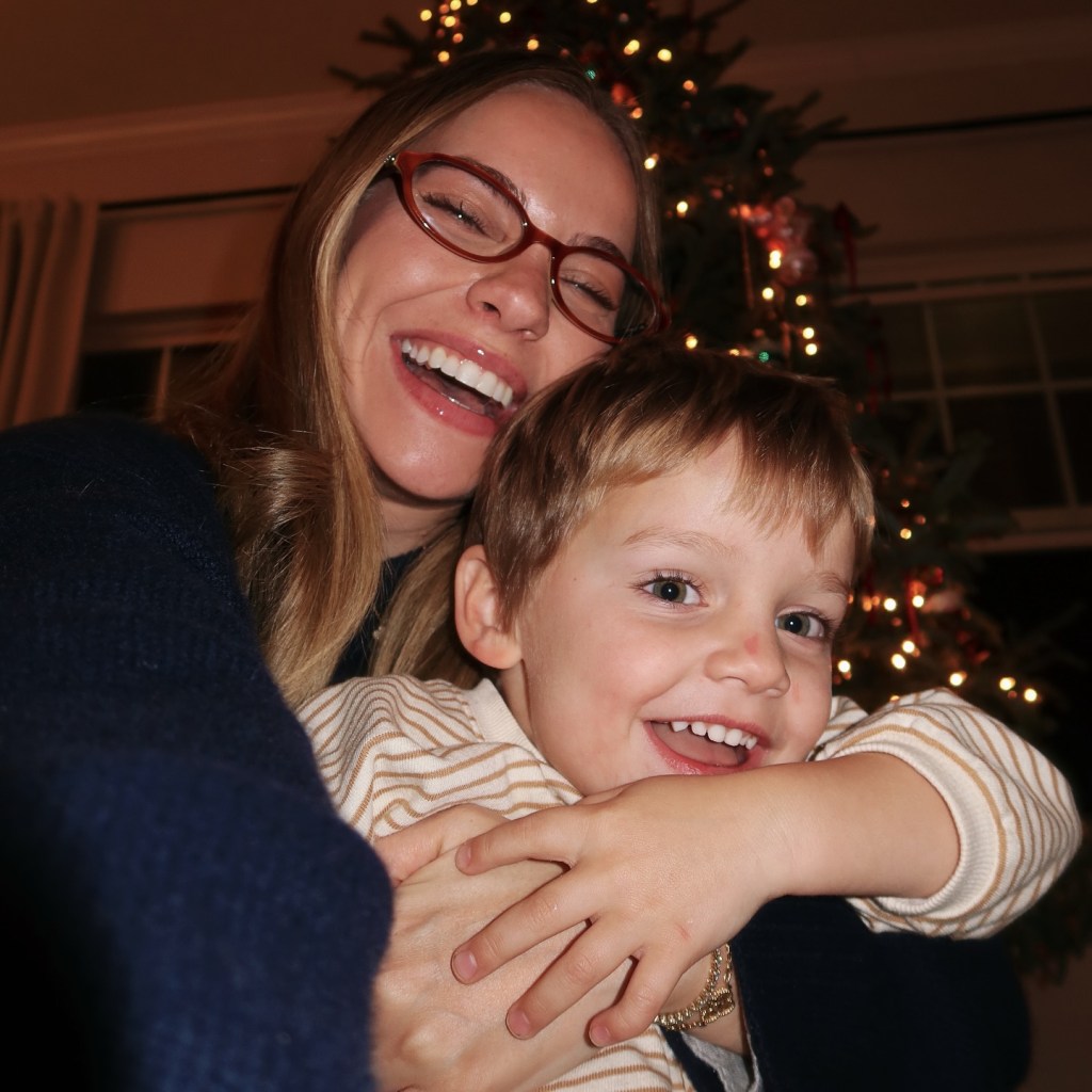 Emilie Kiser laughing and holding her son Trigg, who is also laughing.