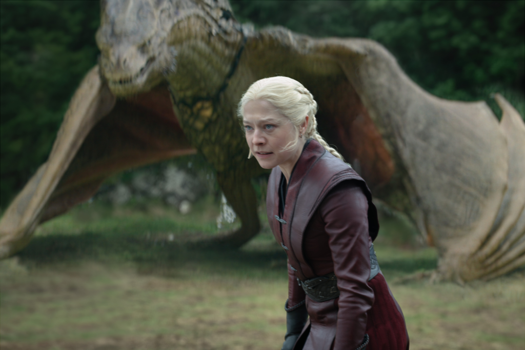 Emma D'Arcy as Rhaenyra Targaryen in House of the Dragon, with a dragon in the background.