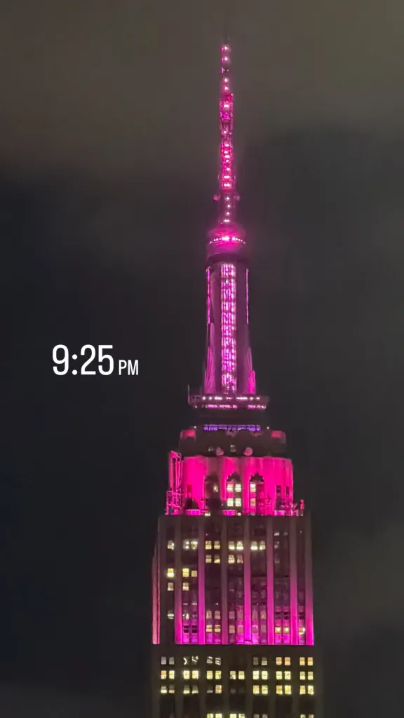 The Empire State Building lit up in pink at 9:25 PM.