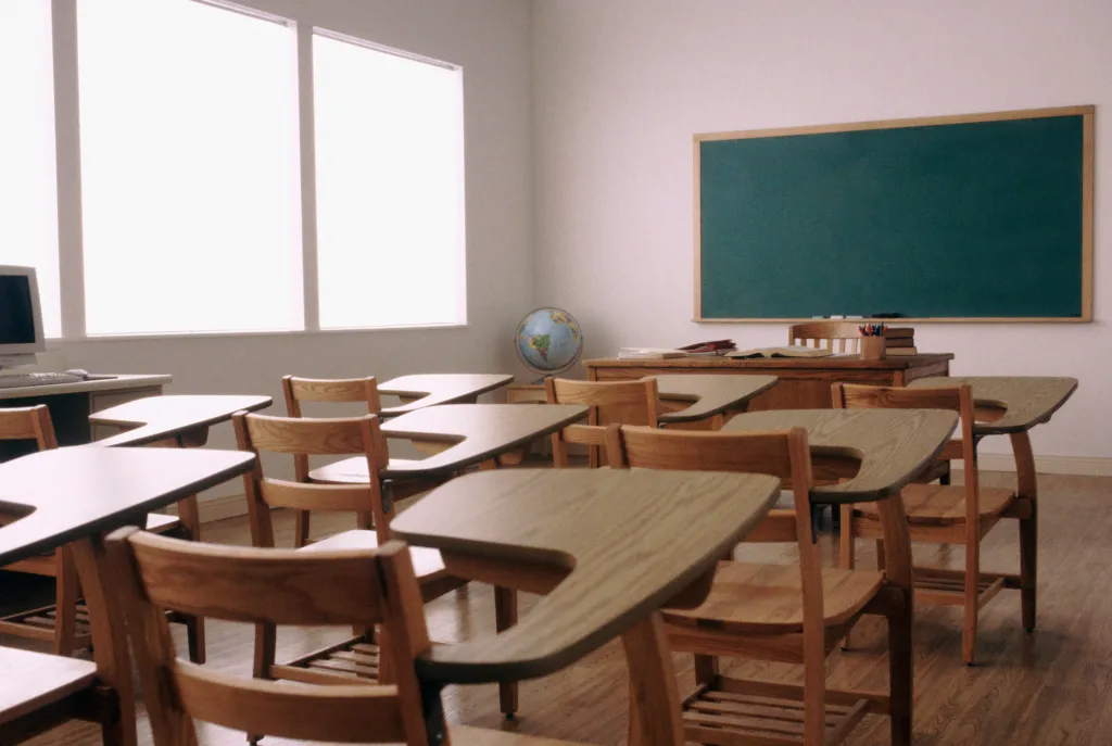 Empty desks and chairs in an elementary school classroom.