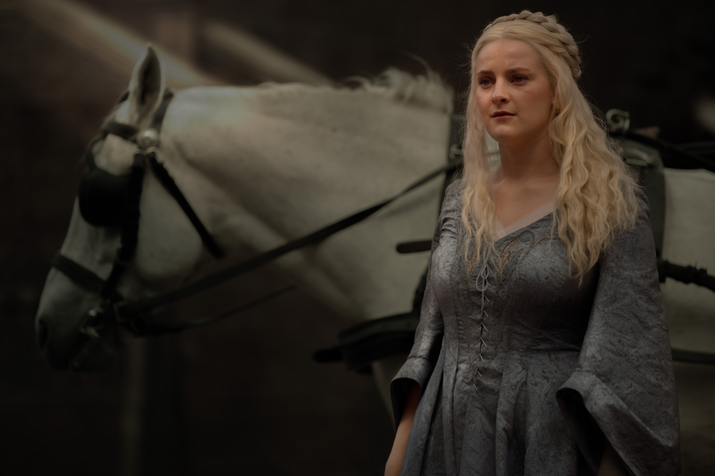 Phia Saban as Princess Helaena Targaryen in House of the Dragon, with a white horse behind her.