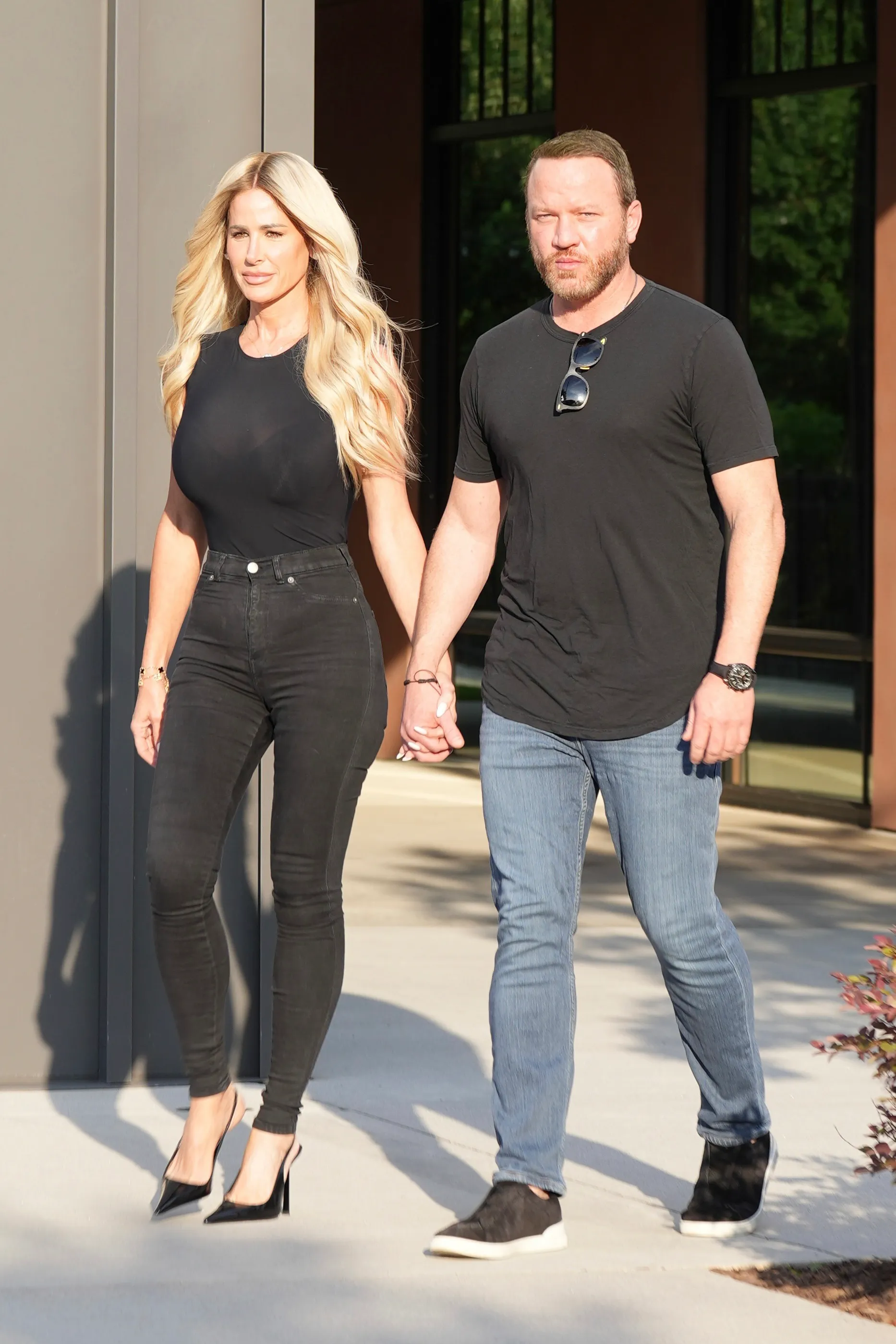 Kim Zolciak and Kyle Mowitz holding hands while walking.