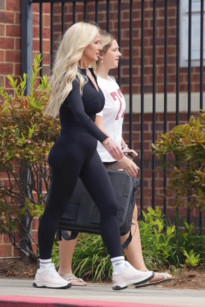 Kim Zolciak in black athletic wear and her daughter Kaia Biermann in a white t-shirt walking together.