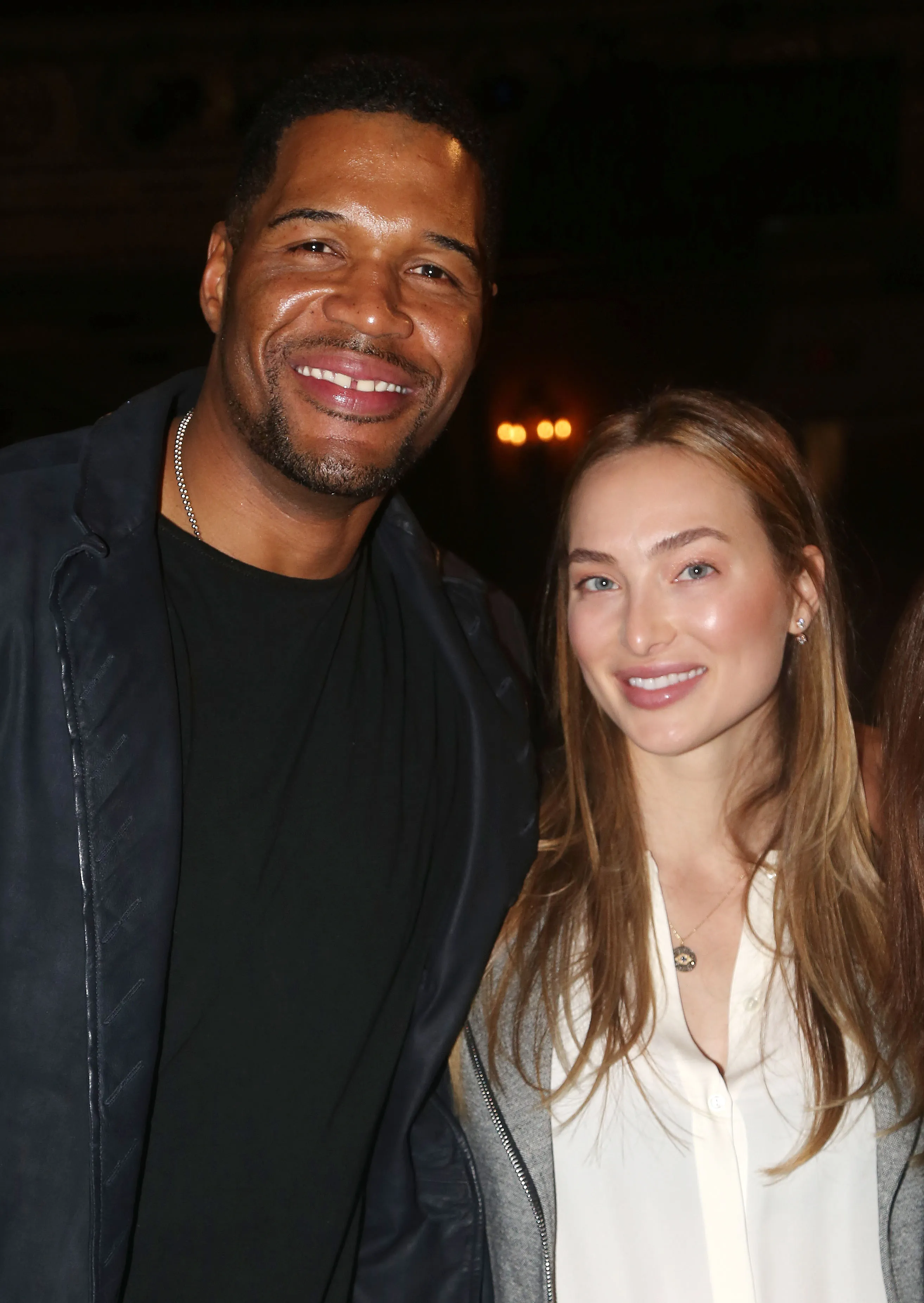 Michael Strahan and his girlfriend, Kayla Quick, smiling at the camera.