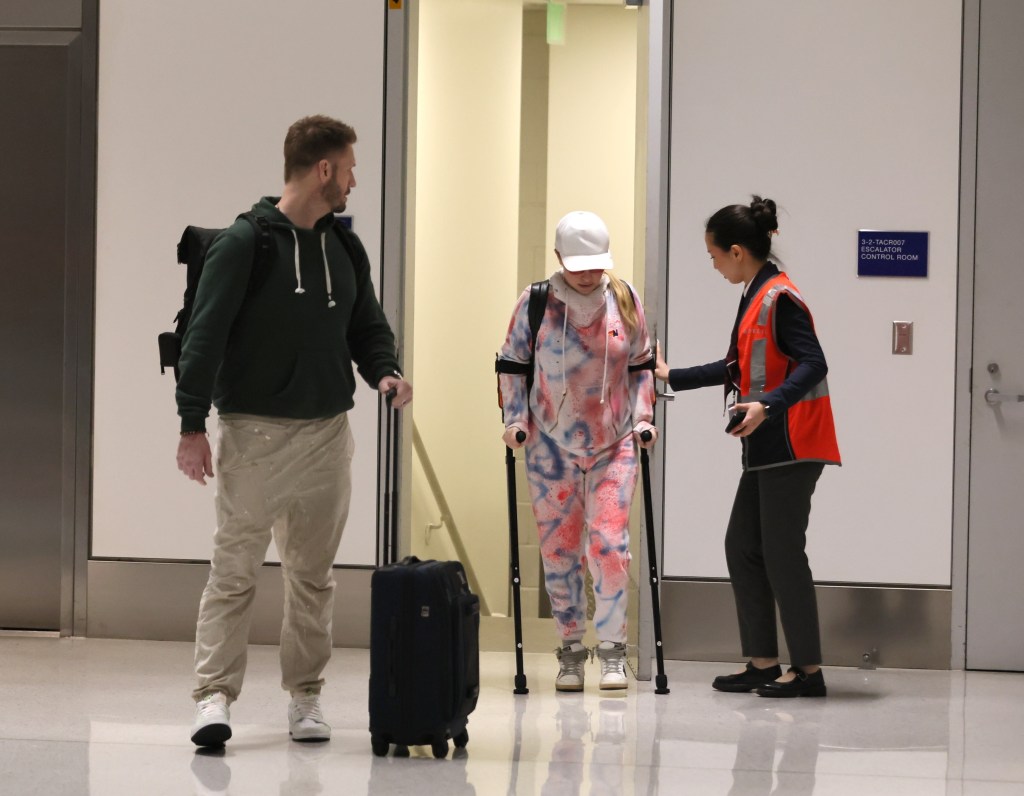 Hayden Panettiere on crutches with Brian Hickerson and an airport employee at LAX.