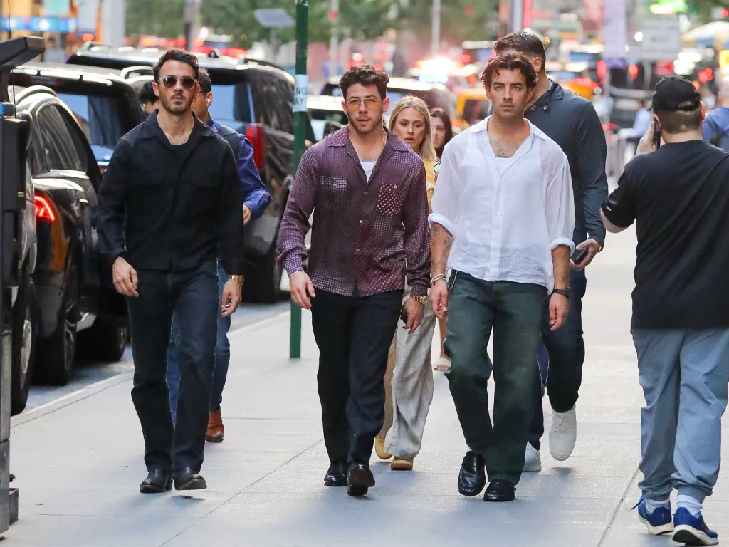 The Jonas Brothers walking through New York City.