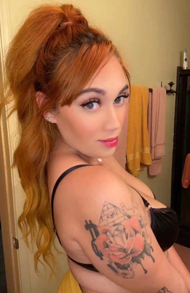 Tatiana McIntyre, also known as Alison Riley, is shown with red hair and a tattoo on her arm.