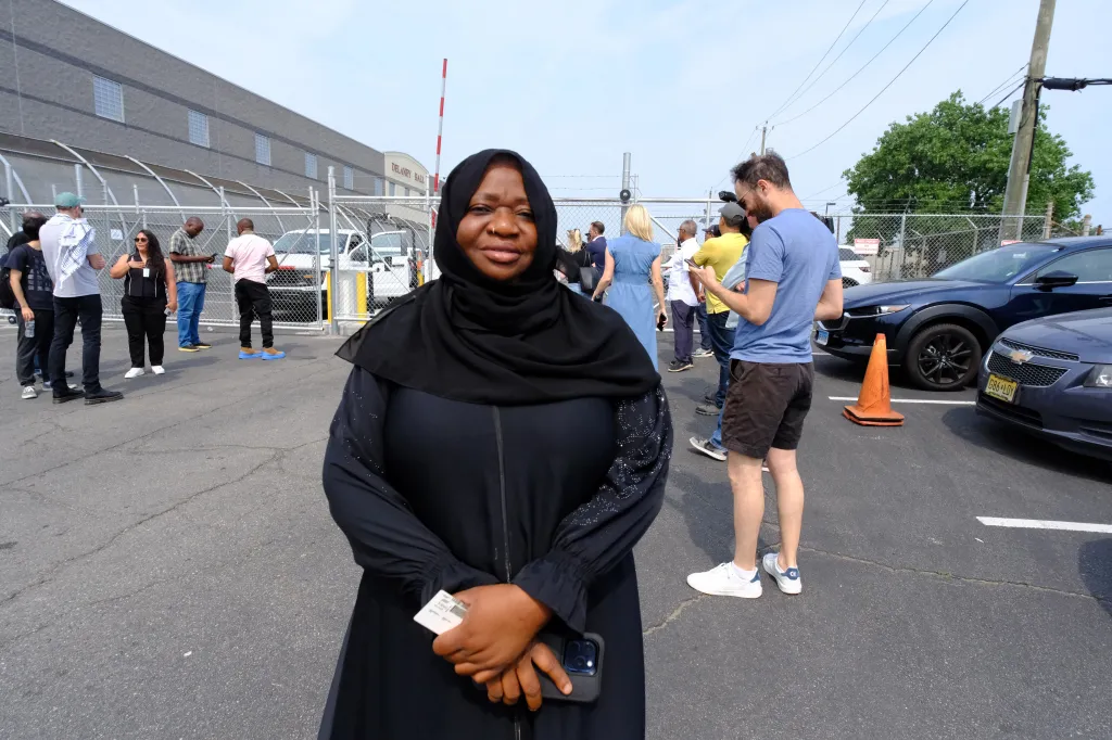 Matila Dullah stands outside the Delaney Hall Detention Facility, seeking information about her brother after a violent uprising.