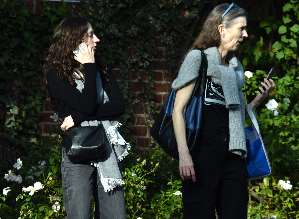 Rose Reiner talking on the phone and Maud Reiner holding a bag and phone.