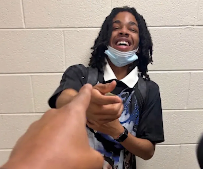 Cameron Frierson, a 16-year-old student, laughing while wearing a mask on his chin.