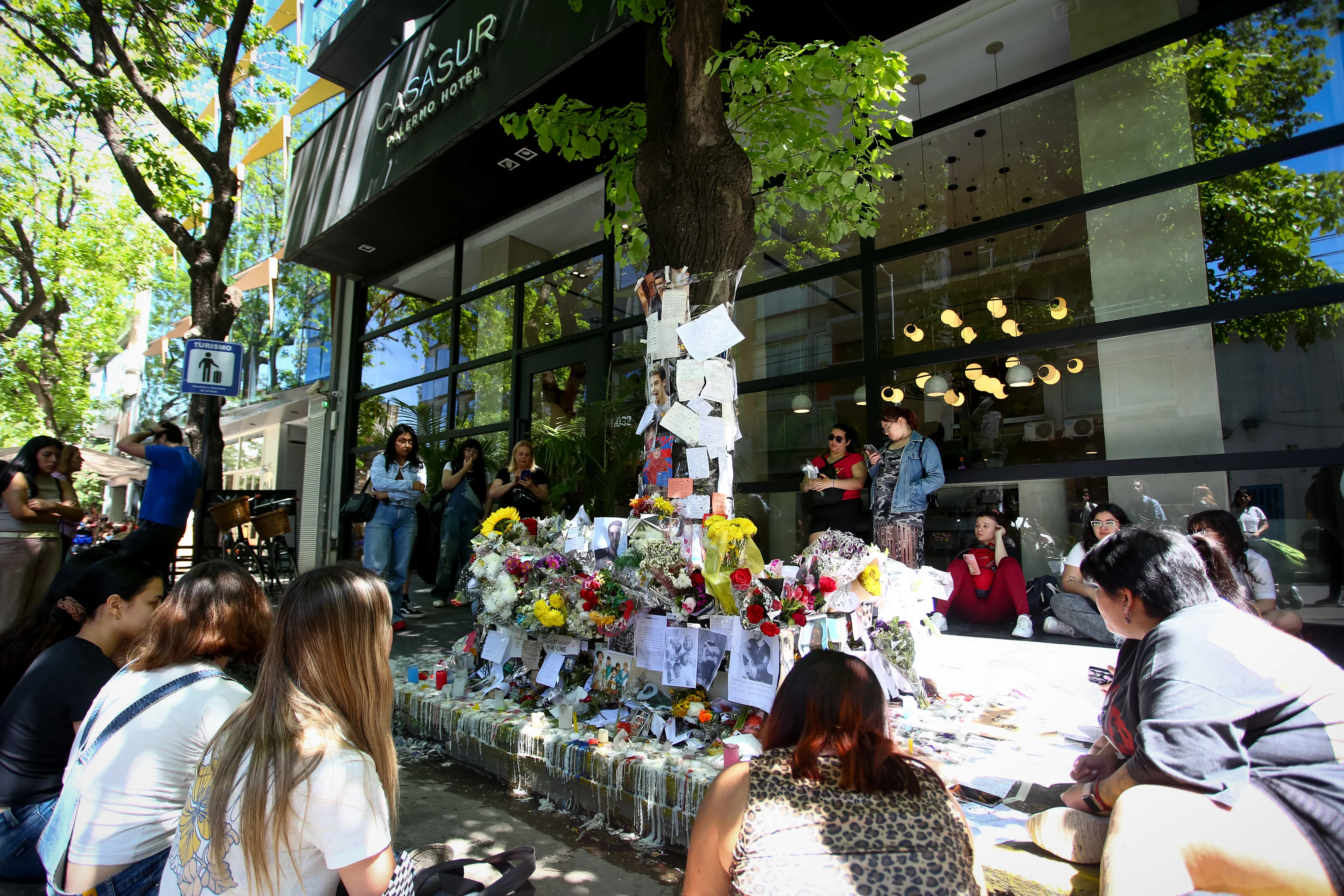 Fans paying tribute to Liam Payne with flowers, candles, and messages in front of the CasaSur hotel.