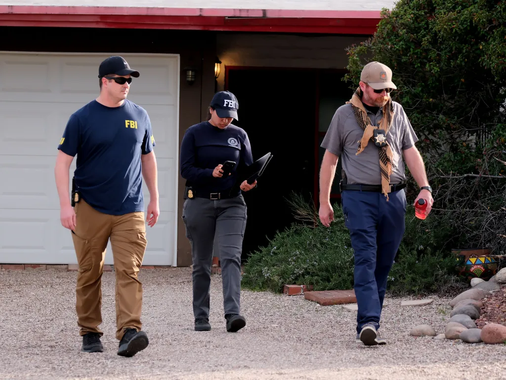 FBI agents walking in a residential neighborhood while searching for Nancy Guthrie.